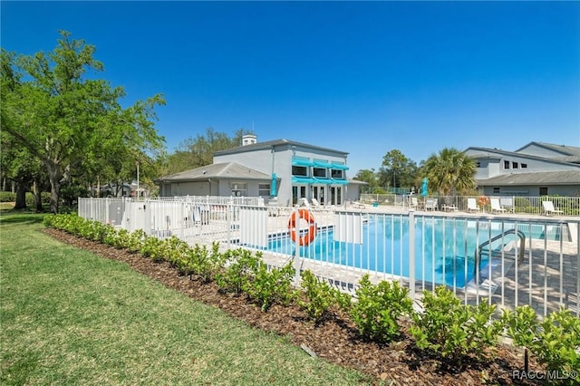 community pool featuring a lawn and fence