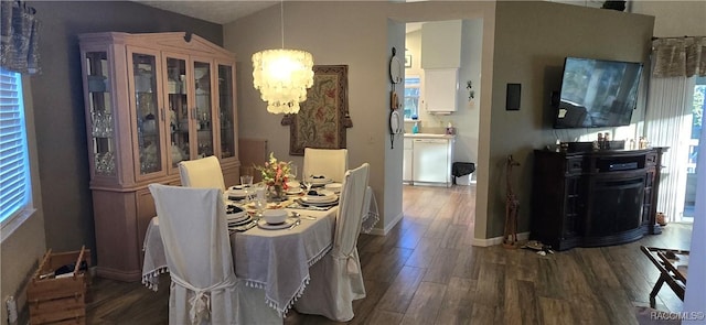 dining room with a notable chandelier, dark wood-style floors, baseboards, and a wealth of natural light