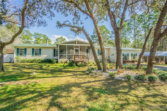 view of front of property with a sunroom and a front lawn