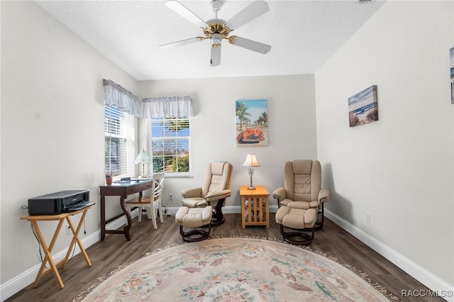 living area with dark wood-type flooring and ceiling fan