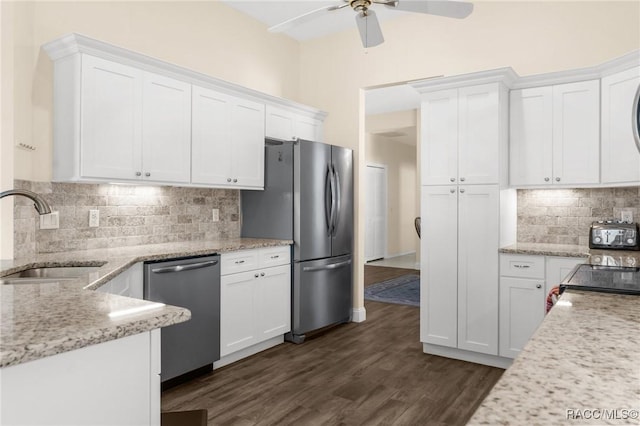 kitchen featuring sink, stainless steel appliances, dark hardwood / wood-style floors, light stone counters, and white cabinets