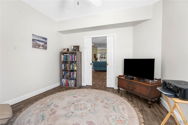 living area with dark hardwood / wood-style floors and ceiling fan