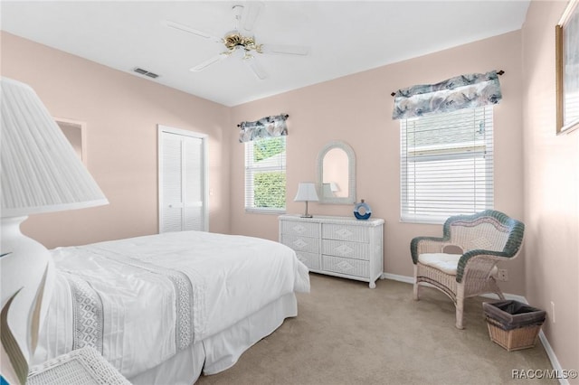 bedroom featuring ceiling fan, a closet, and light carpet