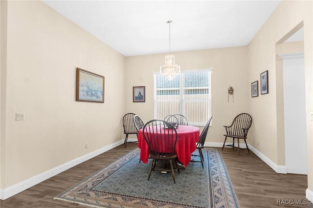 dining room with dark hardwood / wood-style flooring and an inviting chandelier