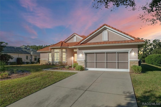 mediterranean / spanish house featuring a garage and a lawn