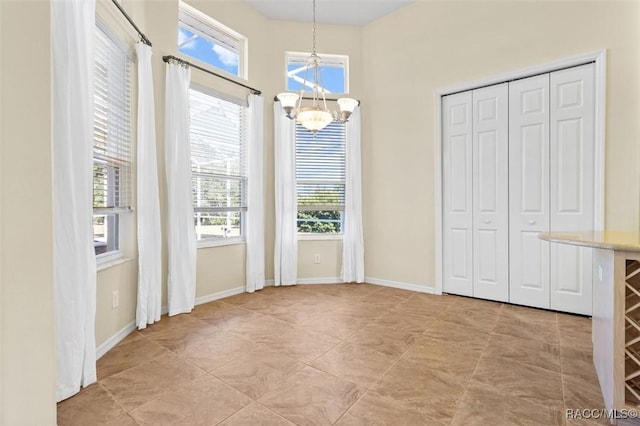 unfurnished dining area featuring a chandelier