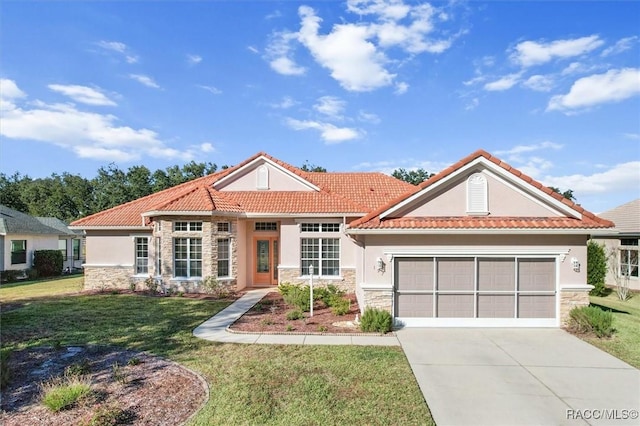 mediterranean / spanish home featuring a garage and a front lawn