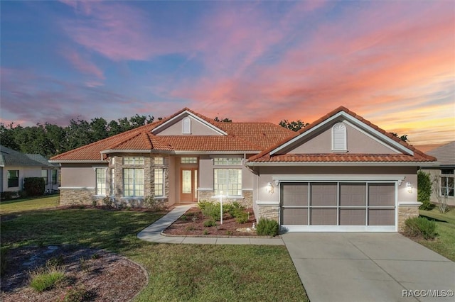 view of front of house with a yard and a garage