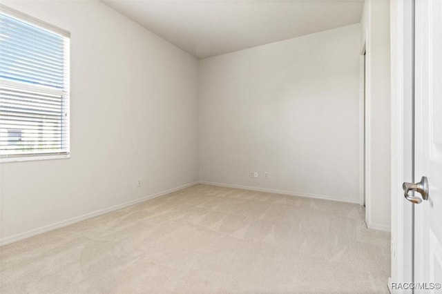 unfurnished room featuring light colored carpet