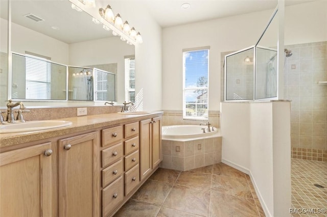 bathroom with vanity and shower with separate bathtub