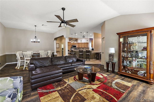 living room with ceiling fan with notable chandelier, dark hardwood / wood-style floors, vaulted ceiling, and decorative columns