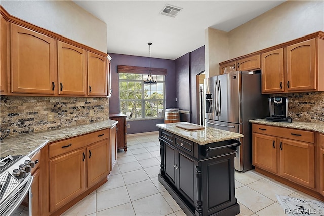 kitchen featuring tasteful backsplash, light stone countertops, and stainless steel appliances