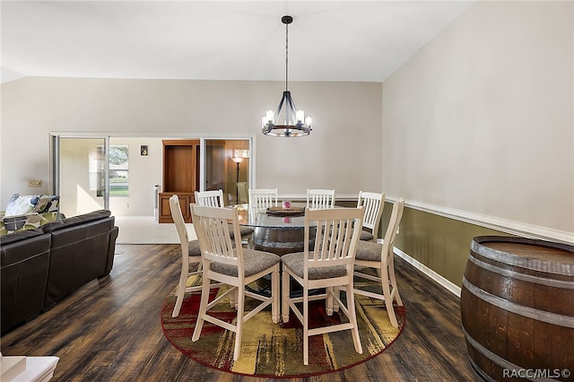 dining area with an inviting chandelier, dark wood-type flooring, and vaulted ceiling