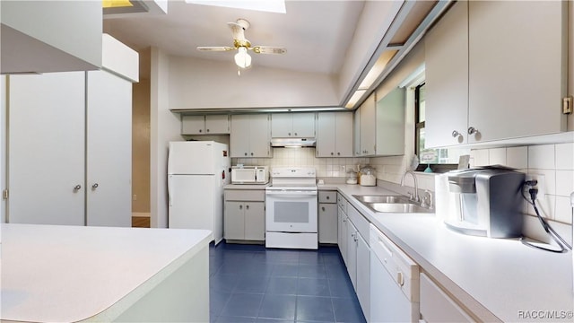 kitchen featuring vaulted ceiling, sink, dark tile patterned flooring, decorative backsplash, and white appliances