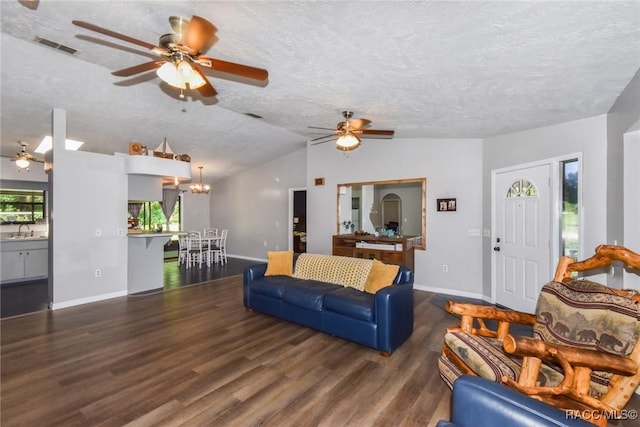 living room featuring lofted ceiling, sink, a textured ceiling, dark hardwood / wood-style floors, and ceiling fan with notable chandelier