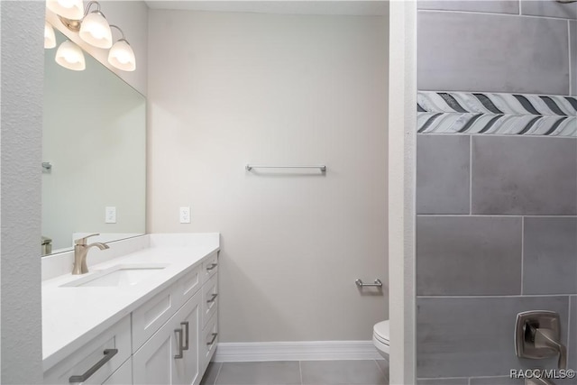 bathroom with toilet, vanity, and tile patterned flooring