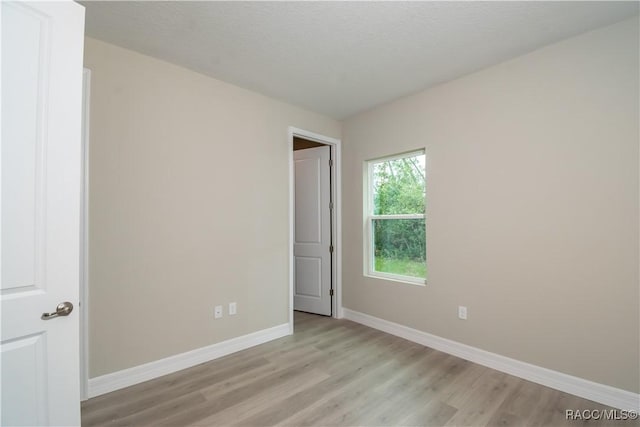 unfurnished bedroom featuring light hardwood / wood-style floors and a textured ceiling