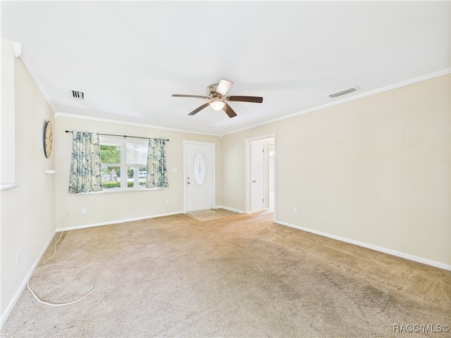 spare room featuring a ceiling fan, ornamental molding, light carpet, and baseboards