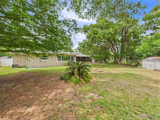 view of yard featuring central AC, a storage unit, and an outdoor structure