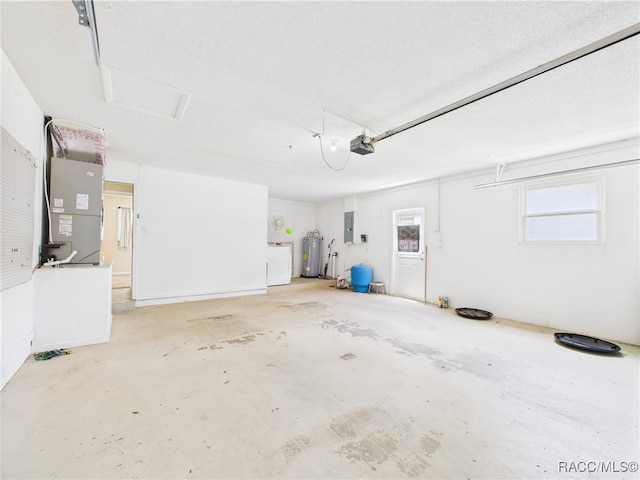 garage with a garage door opener, electric water heater, and washer / dryer