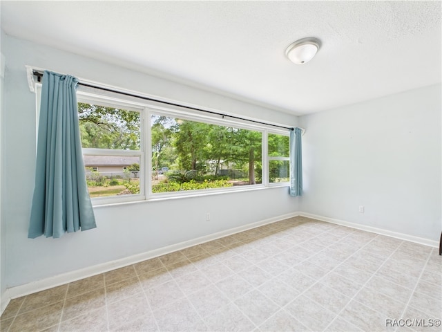 spare room with baseboards