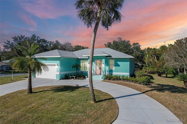 view of front of home with a yard and a garage