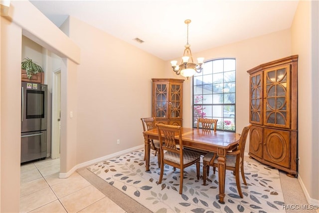 dining space featuring light tile patterned floors and a notable chandelier