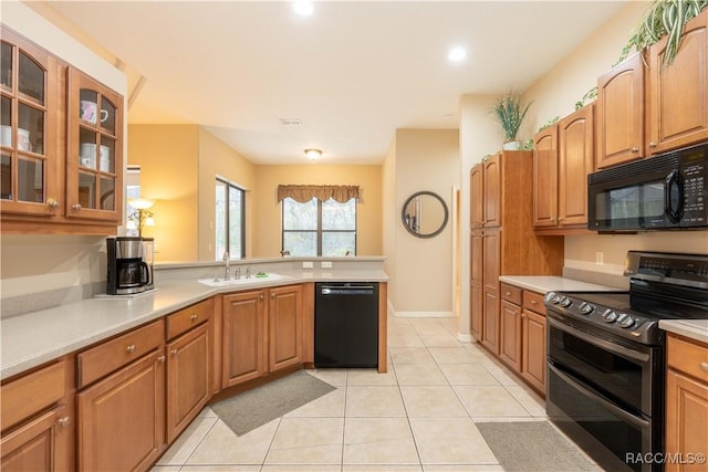 kitchen featuring sink, black appliances, kitchen peninsula, and light tile patterned flooring