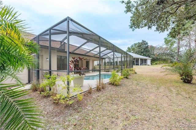 view of swimming pool with a lanai and a lawn