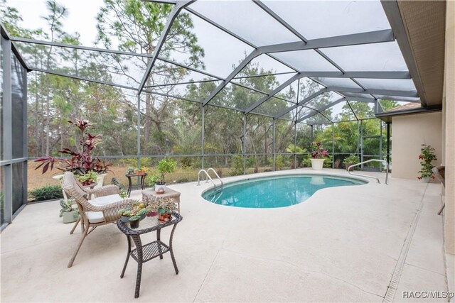 view of pool featuring a patio and glass enclosure