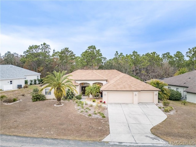 view of front of home with a garage and central air condition unit