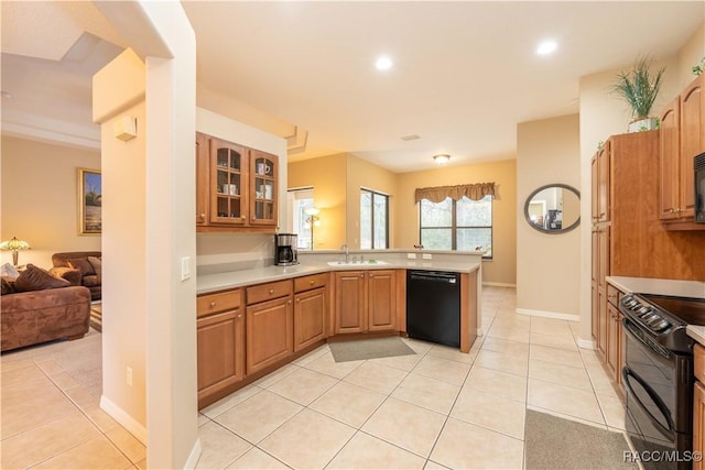 kitchen featuring sink, light tile patterned floors, black appliances, and kitchen peninsula