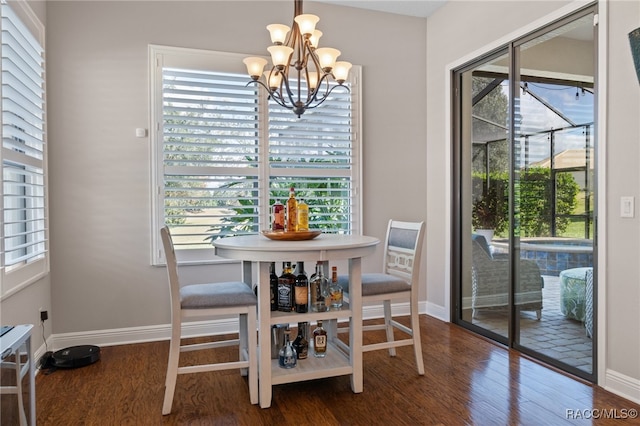 dining room with dark hardwood / wood-style flooring and a notable chandelier