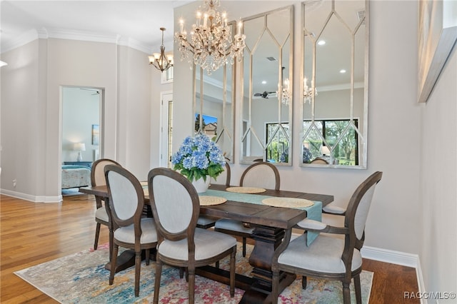 dining space featuring crown molding, wood-type flooring, and a notable chandelier