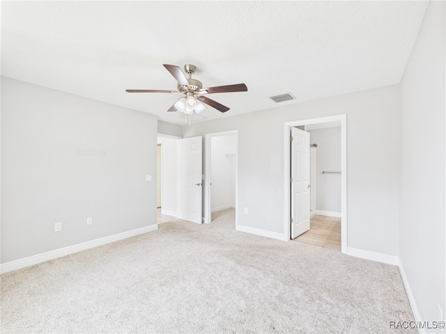 1899 W Oliver Dr, Citrus Springs, FL 34434 - unfurnished bedroom featuring light carpet, a walk in closet, a ceiling fan, and a closet