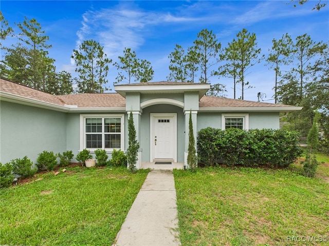 1899 W Oliver Dr, Citrus Springs, FL 34434 - view of front of home with stucco siding, a front yard, and a shingled roof