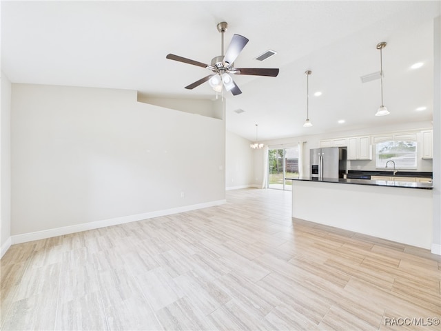 1899 W Oliver Dr, Citrus Springs, FL 34434 - unfurnished living room with lofted ceiling, a ceiling fan, a chandelier, light wood-style floors, and recessed lighting