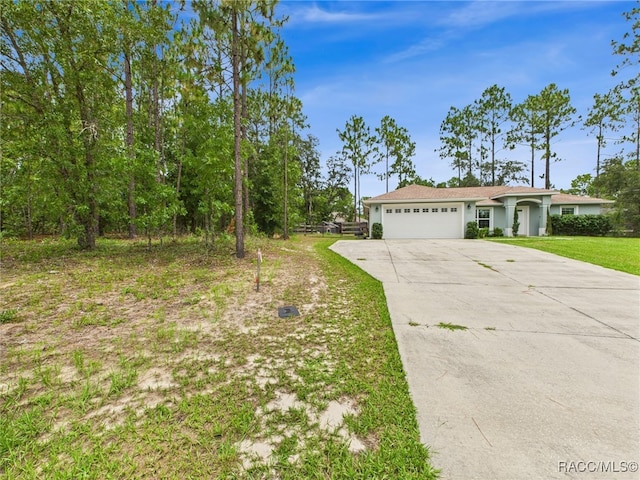 1899 W Oliver Dr, Citrus Springs, FL 34434 - view of front of property featuring a garage, driveway, and a front lawn