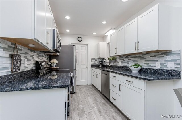 340 E Glassboro Ct Unit 19-5A, Hernando, FL 34442 - kitchen featuring stainless steel appliances, white cabinets, light wood-style flooring, decorative backsplash, and recessed lighting