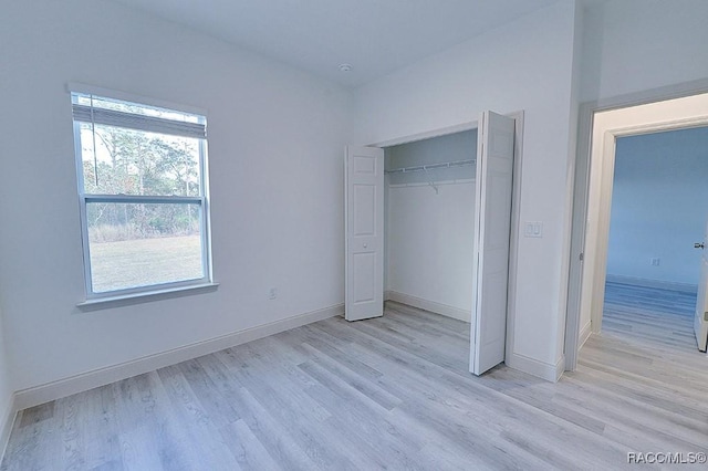 unfurnished bedroom featuring a closet and light wood-type flooring