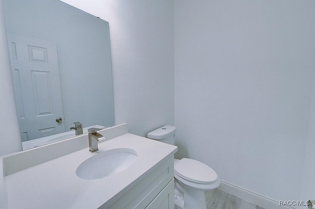 bathroom featuring hardwood / wood-style floors, vanity, and toilet