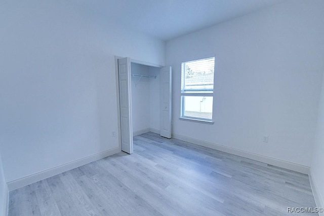 unfurnished bedroom featuring light wood-type flooring and a closet