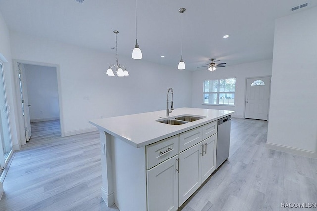 kitchen featuring stainless steel dishwasher, light hardwood / wood-style flooring, sink, and an island with sink