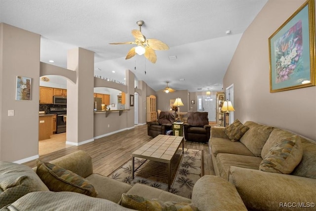 15776 SW 11th Terrace Rd, Ocala, FL 34473 - living area featuring arched walkways, ceiling fan, light wood-style flooring, and vaulted ceiling