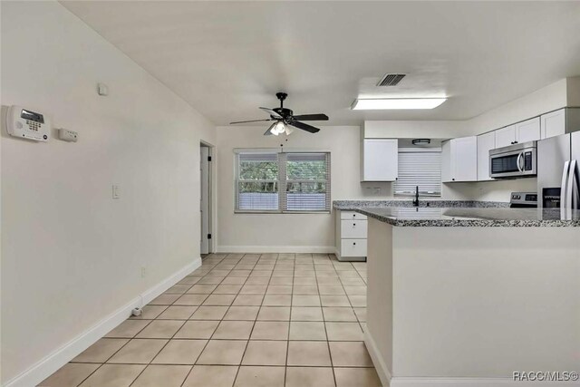 657 NE 11th St, Crystal River, FL 34428 - kitchen featuring stainless steel appliances, white cabinets, a ceiling fan, a sink, and baseboards