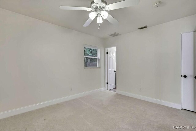 657 NE 11th St, Crystal River, FL 34428 - unfurnished bedroom with light colored carpet, baseboards, and a ceiling fan