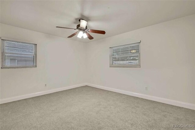 657 NE 11th St, Crystal River, FL 34428 - spare room featuring carpet, baseboards, and a ceiling fan