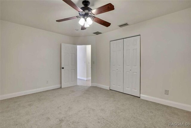 657 NE 11th St, Crystal River, FL 34428 - unfurnished bedroom with light carpet, baseboards, a closet, and ceiling fan