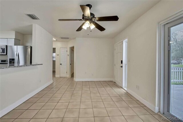 657 NE 11th St, Crystal River, FL 34428 - spare room with a ceiling fan, light tile patterned floors, and baseboards