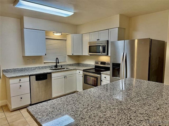 657 NE 11th St, Crystal River, FL 34428 - kitchen featuring appliances with stainless steel finishes, a sink, light stone counters, and white cabinetry